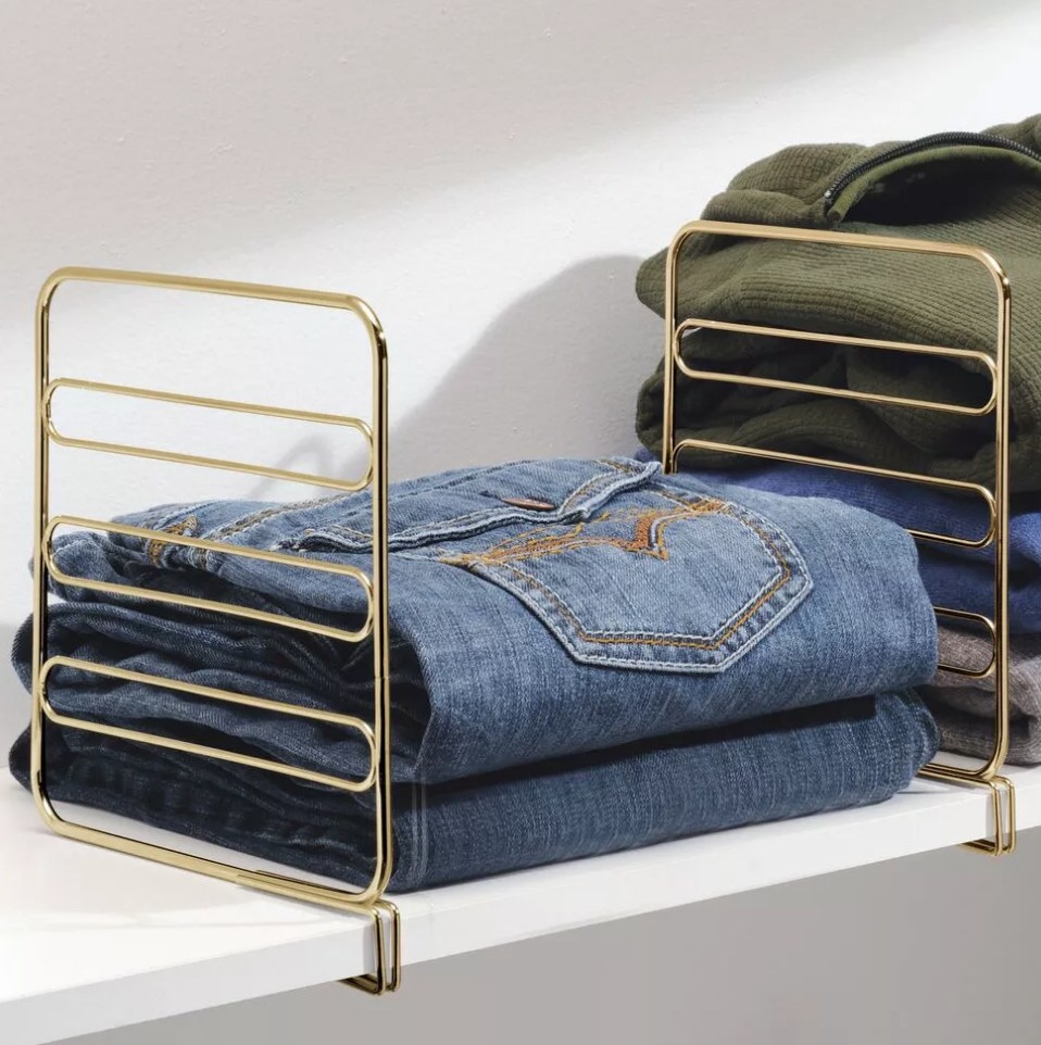 Gold metal wire shelf dividers separating clothes