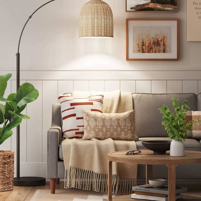 A black floor lamp with a rattan dome shade in a living room