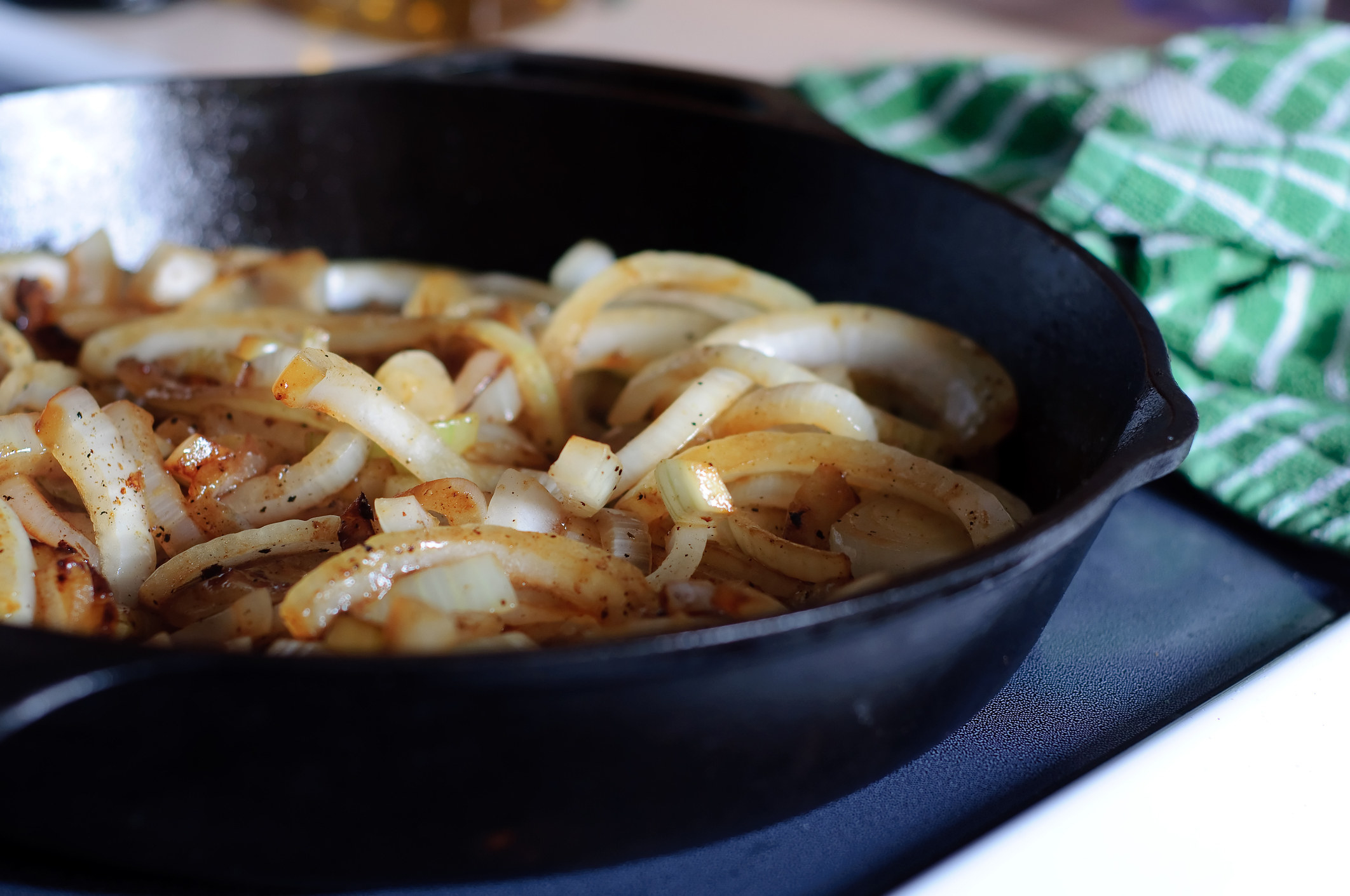 A stock image of sautéed onions in a cast-iron skillet