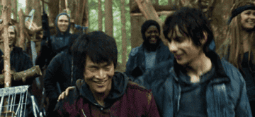 Devon Bostick as Jasper and Christopher Larkin as Monty walking together and smiling in &quot;The 100&quot;