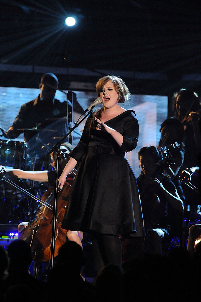 Adele in all black performing on stage