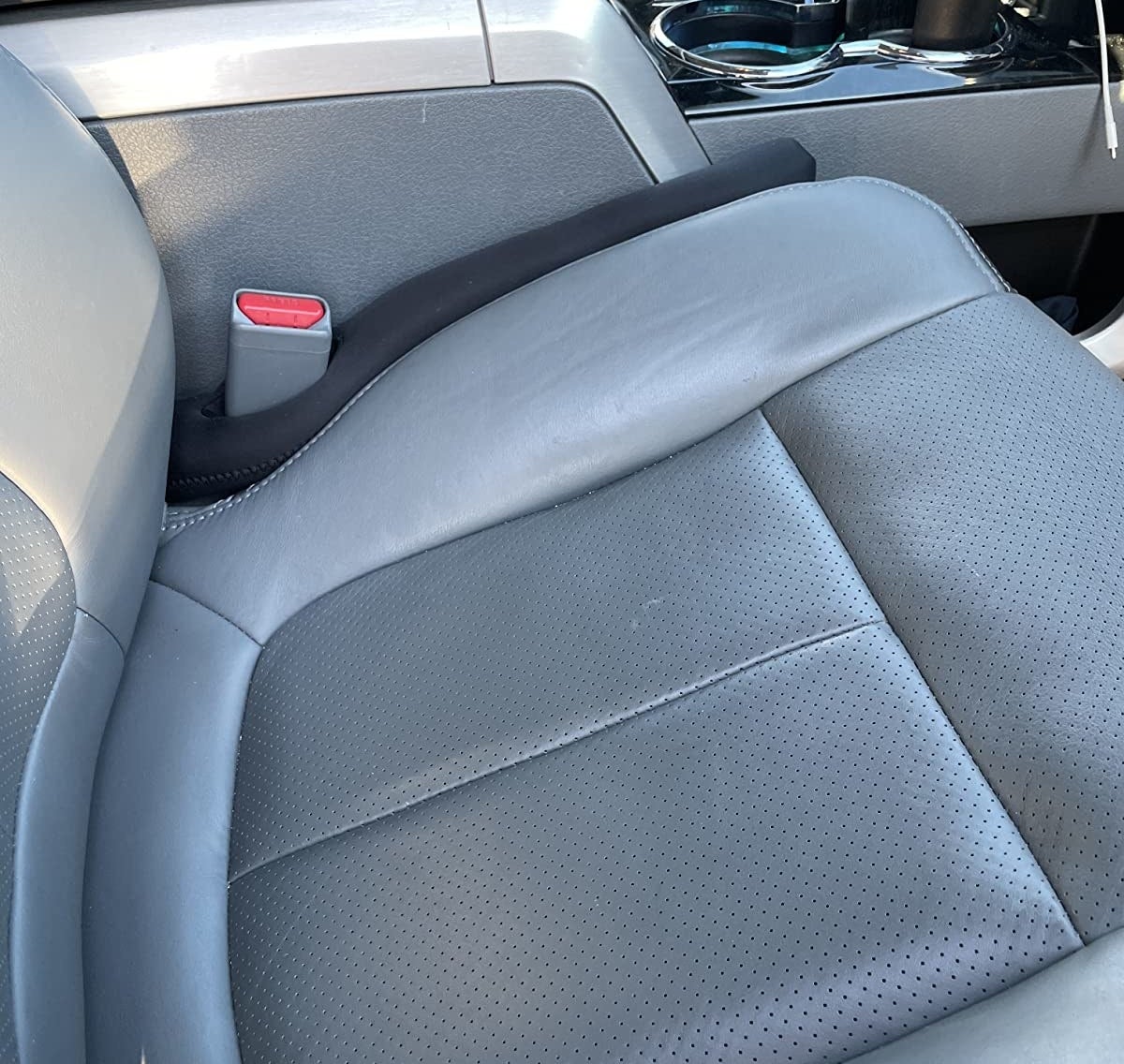 reviewer image of the drop stop gap filler in the gap between the passenger seat