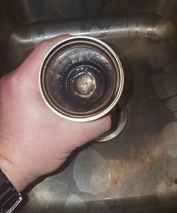before image of reviewer holding dirty travel mug