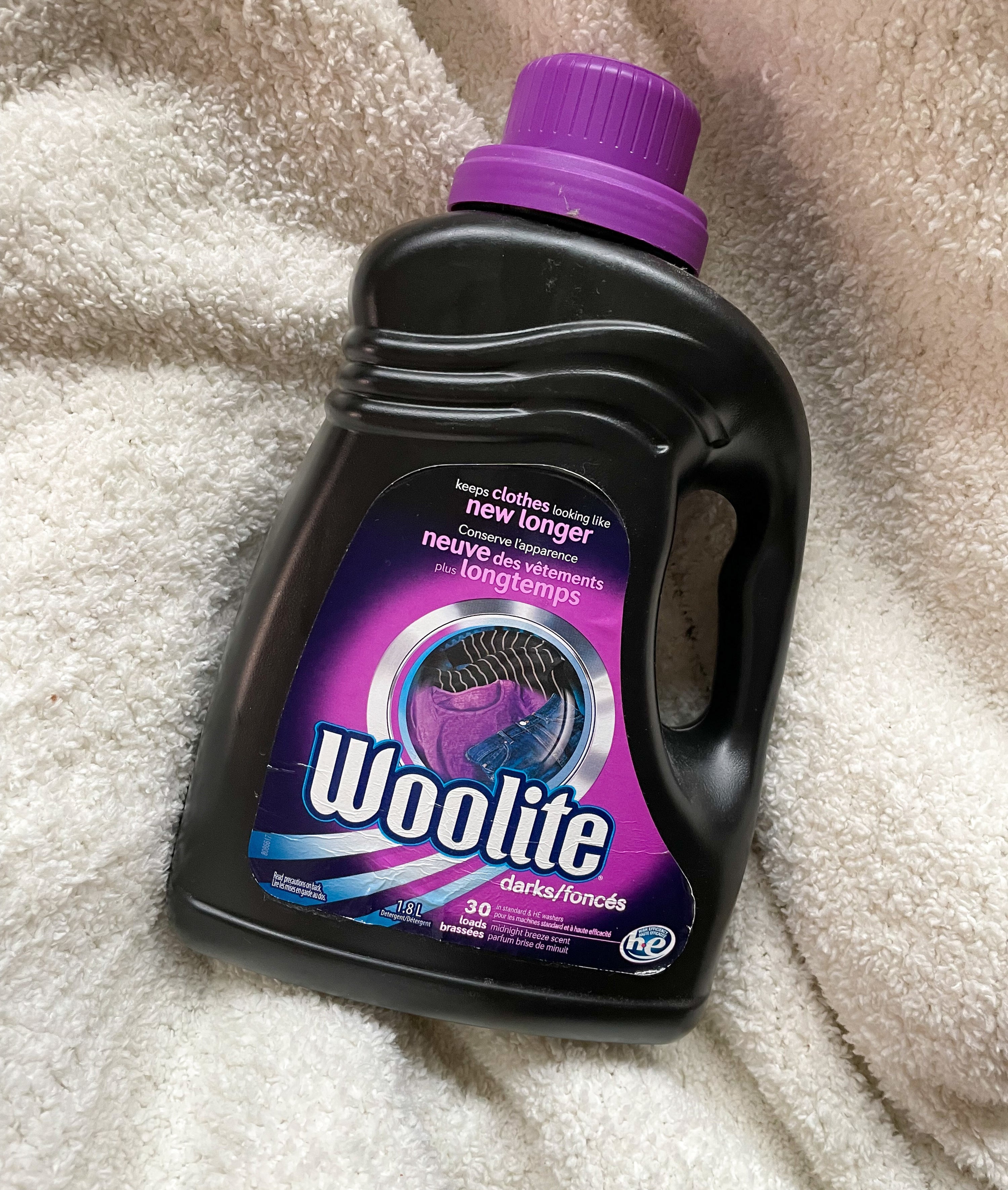 a bottle of woolite detergent on a fluffy blanket