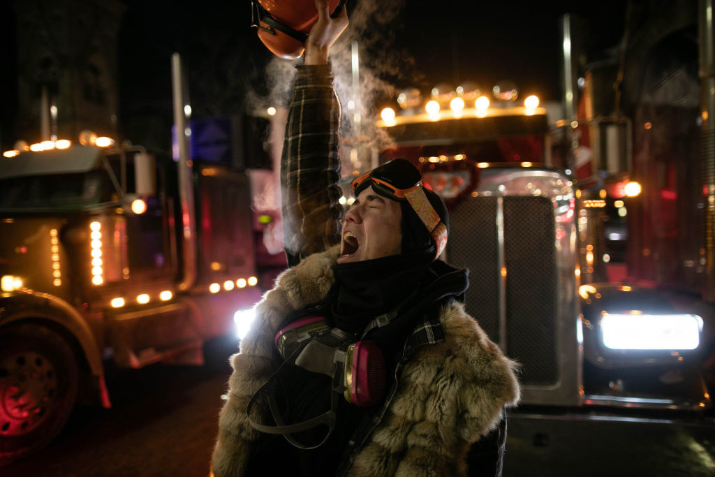 lit from behind by a semi&#x27;s headlights, a trucker chants in protest