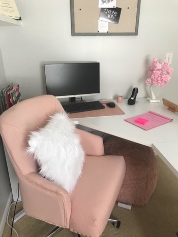 reviewer pic of a pink chair in a home office with white pillow