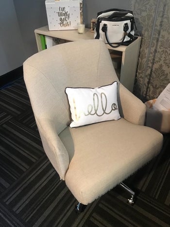 reviewer pic of the same chair in Twill color with a pillow on it