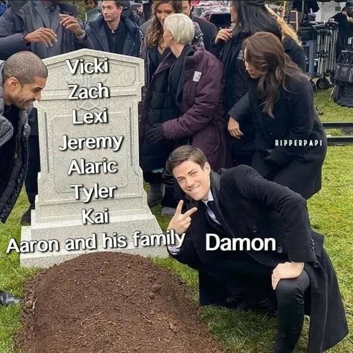 A man makes a V sign and poses in front of someone&#x27;s grave