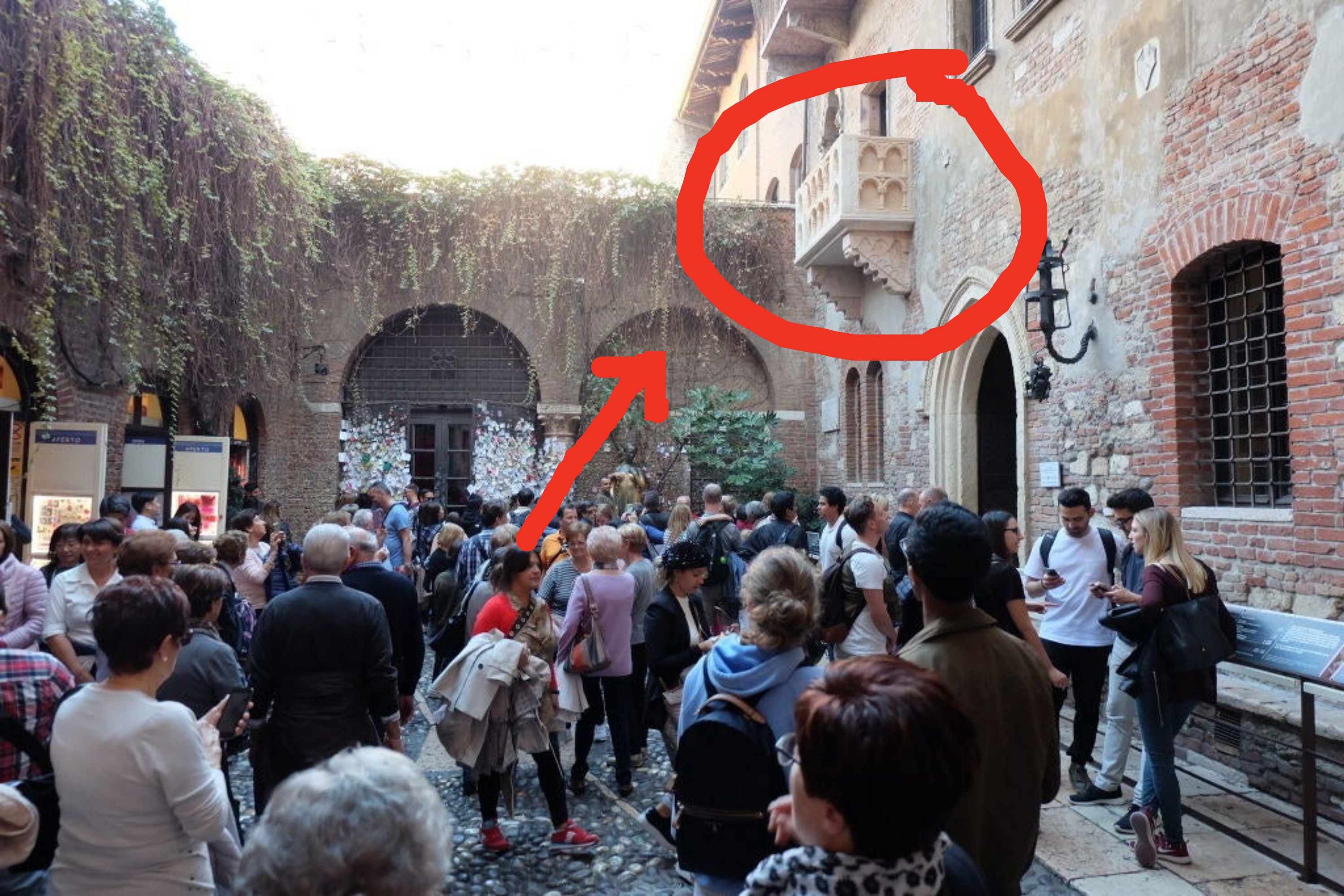 A crowd of tourists underneath the balcony in Verona