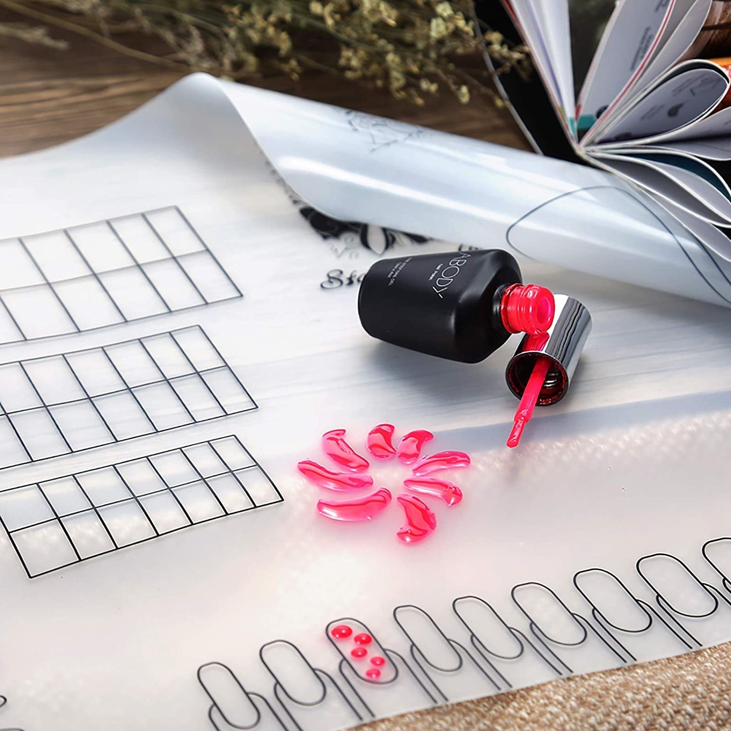 An open bottle of nail polish on the nail design pad