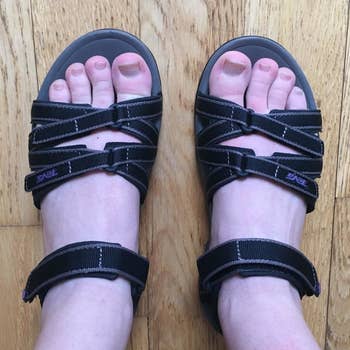 a top-down view of a reviewer wearing the black sandals
