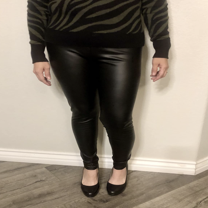 reviewer wearing leggings with zebra print top and heels