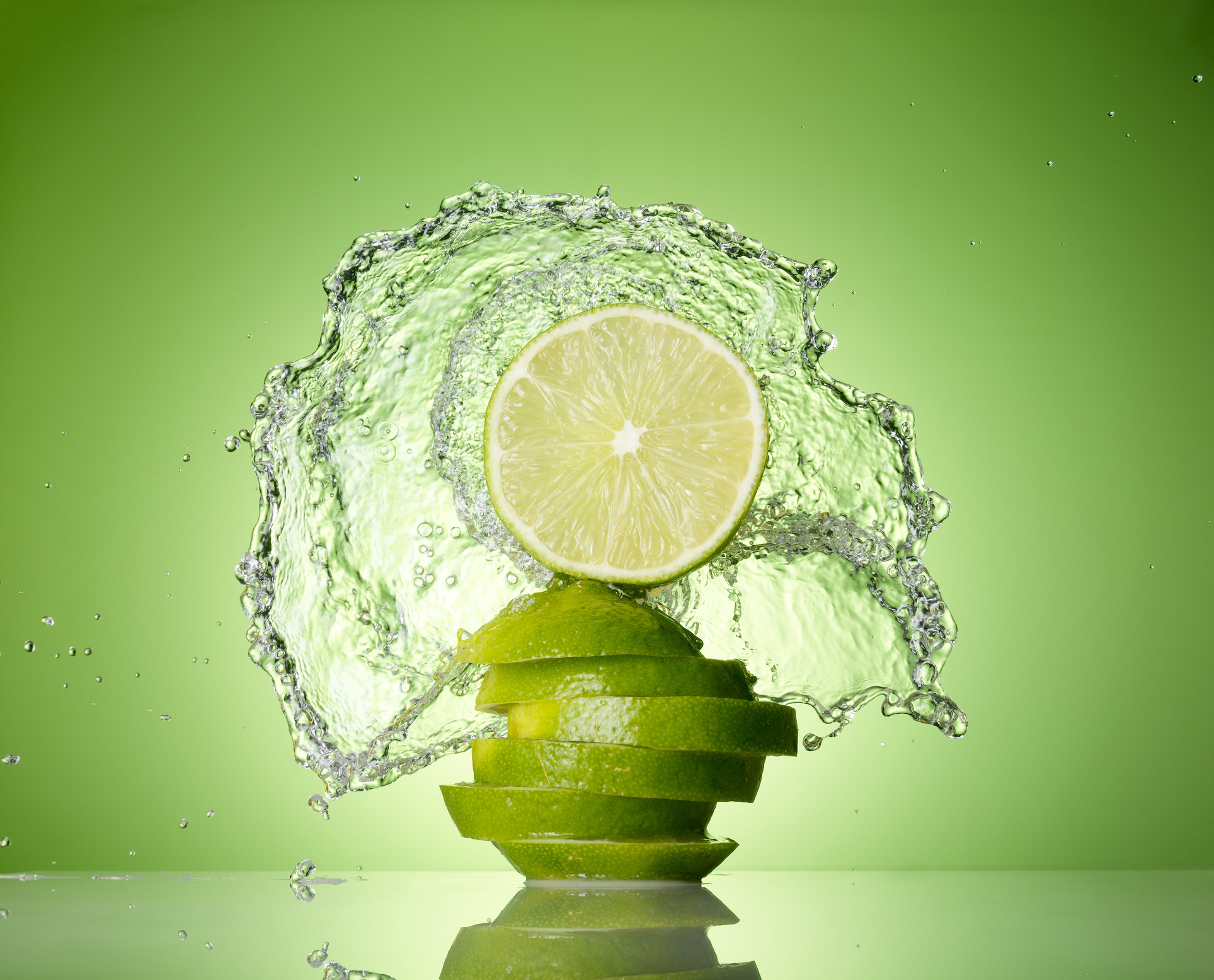 Lime on green background with water splash
