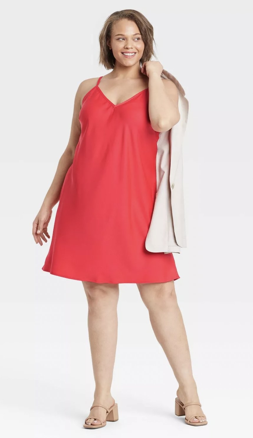 a model wearing the slip dress in coral