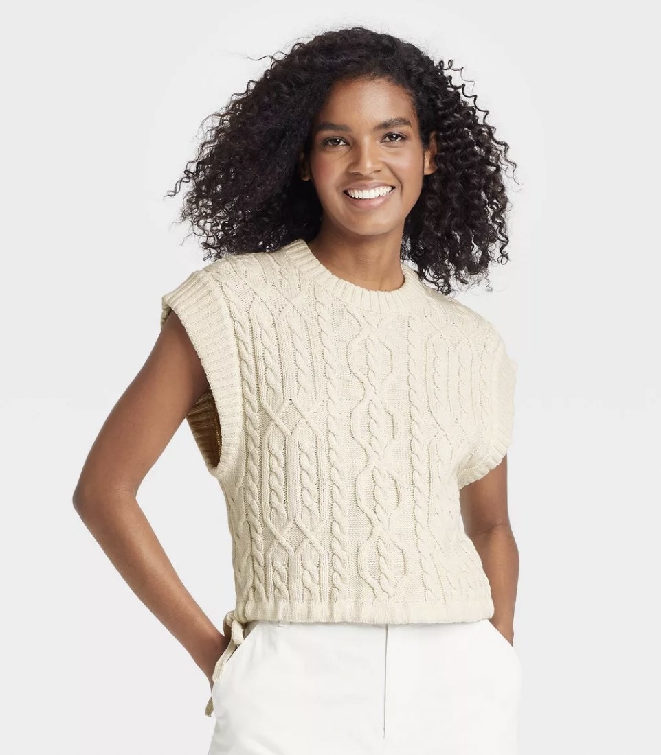 a person wearing a cream sweater vest