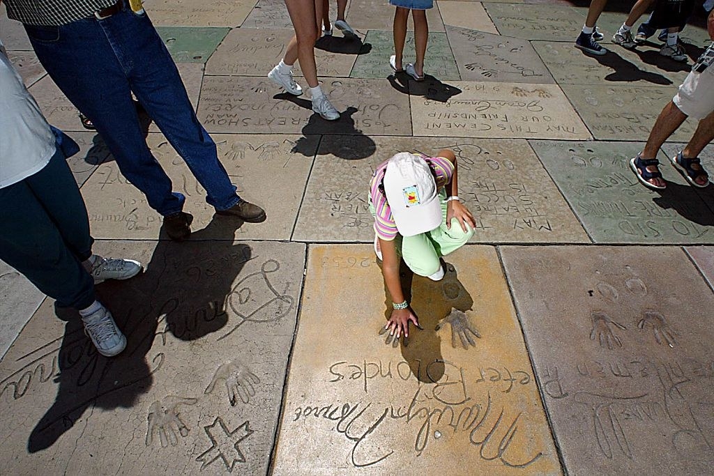 Tourists place their hands on the cement handprints outside Grauman&#x27;s Chinese Theater
