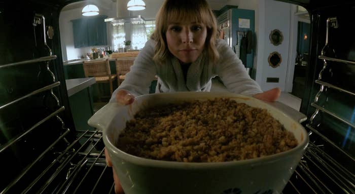 Kristen Bell as Anna in &quot;The Woman In The House Across The Street From The Girl In The Window&quot; pulling a casserole out of her oven without oven mitts
