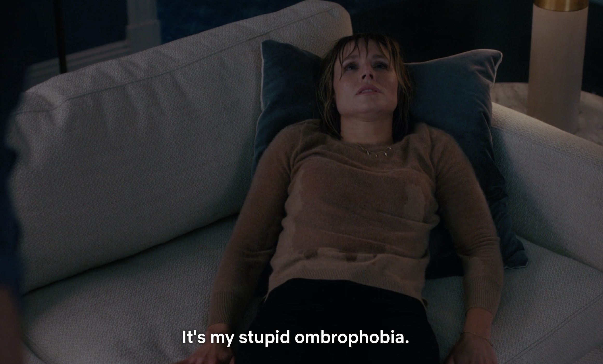 A drenched Kristen Bell laying on a couch complaining about her ombrophobia (fear of the rain)