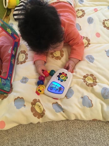 reviewer's photo of their baby holding the toy