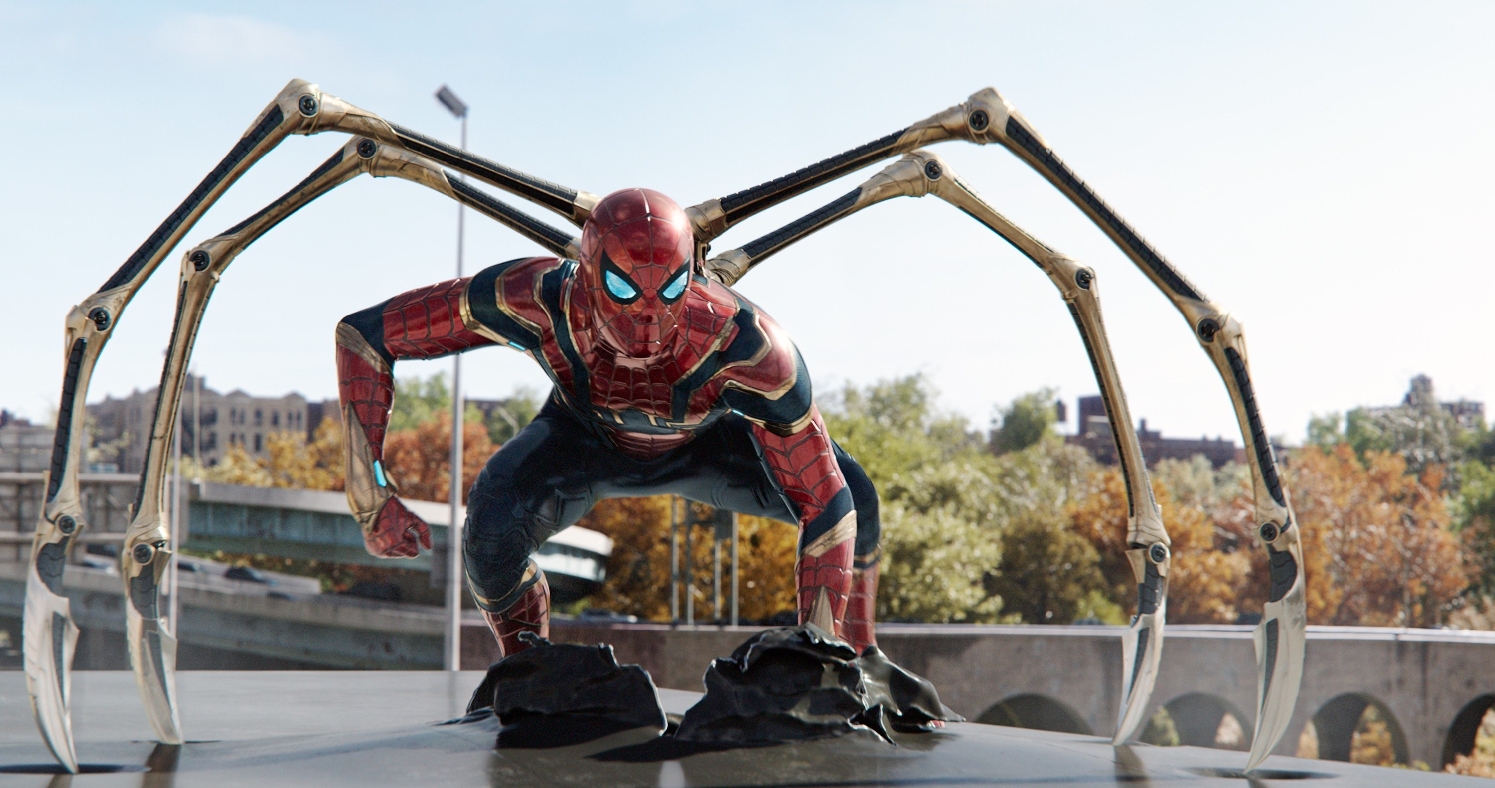 Spider-Man uses his spider suit on top of a car