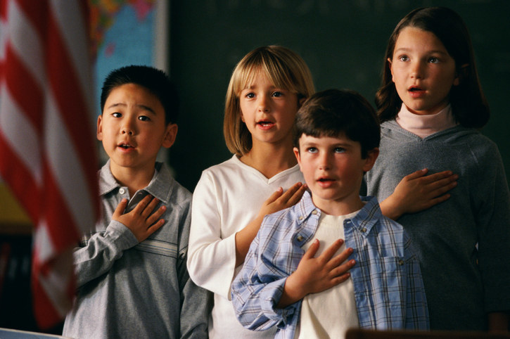 Children with hands over their hearts, reciting the pledge