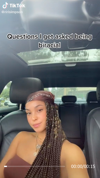 A women in her car on TikTok with the words, &quot;Questions I get asked being biracial&quot;