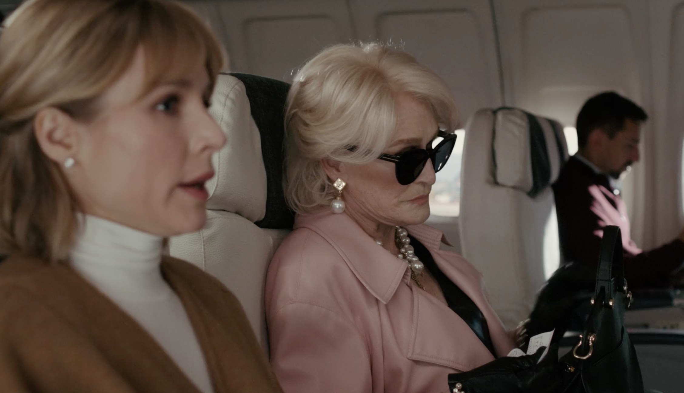 Kristen Bell and Glenn Close seated next to each other on an airplane in the final scene of "The Woman in the House"