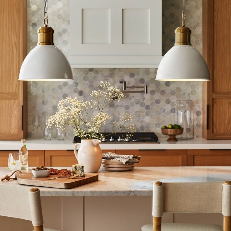 A gold pendant lamp with a white dome shade