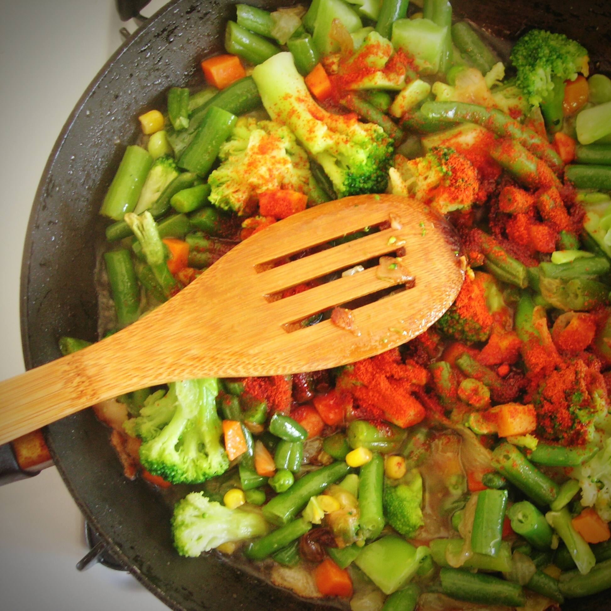 Cooking vegetables with spices in a skillet.
