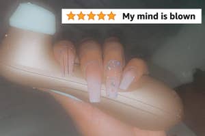 Reviewer holding rose gold suction vibrator with 5-star review