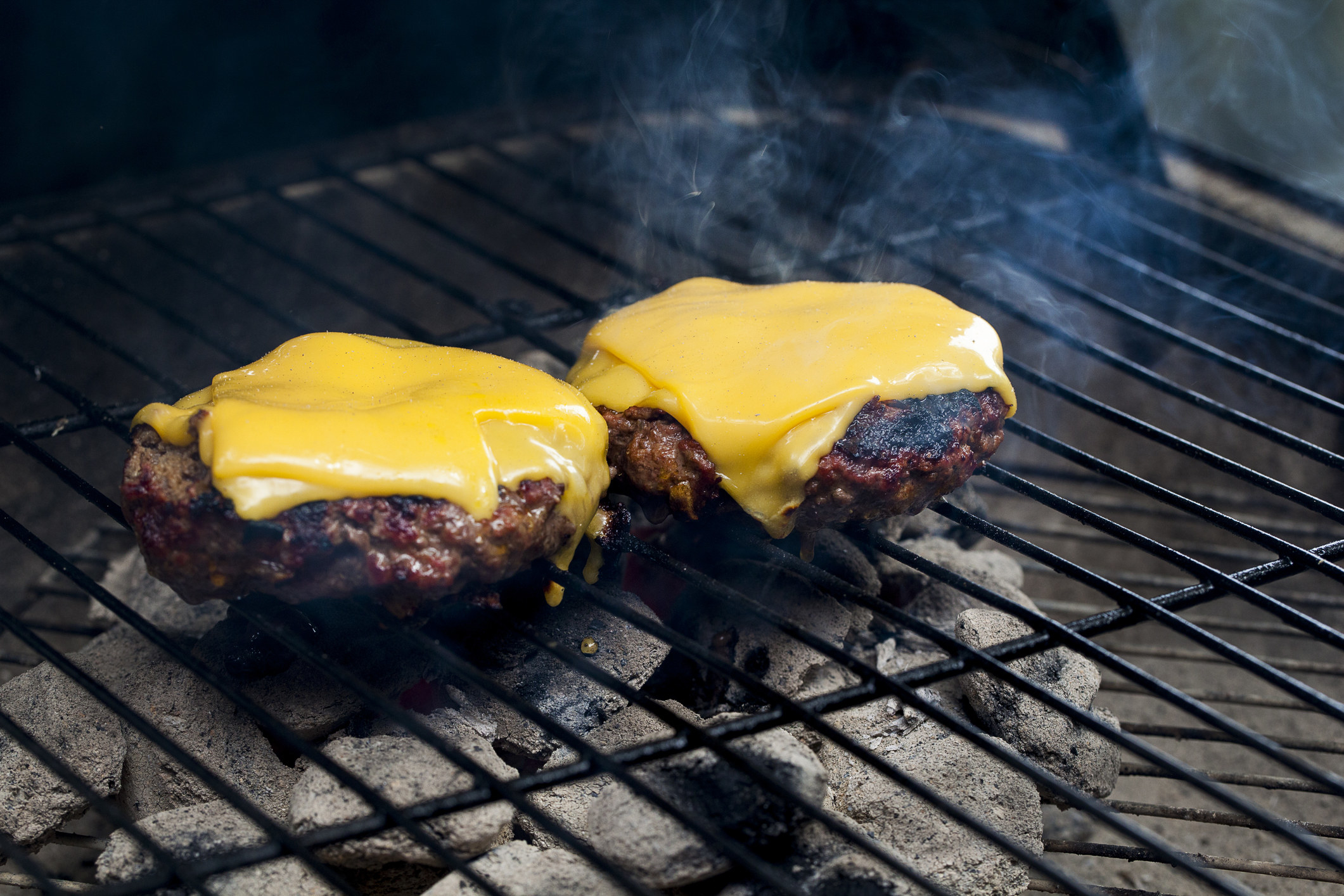 Two cheeseburgers on the grill.