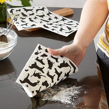a model using one of the dishcloths to wipe flour off the counter