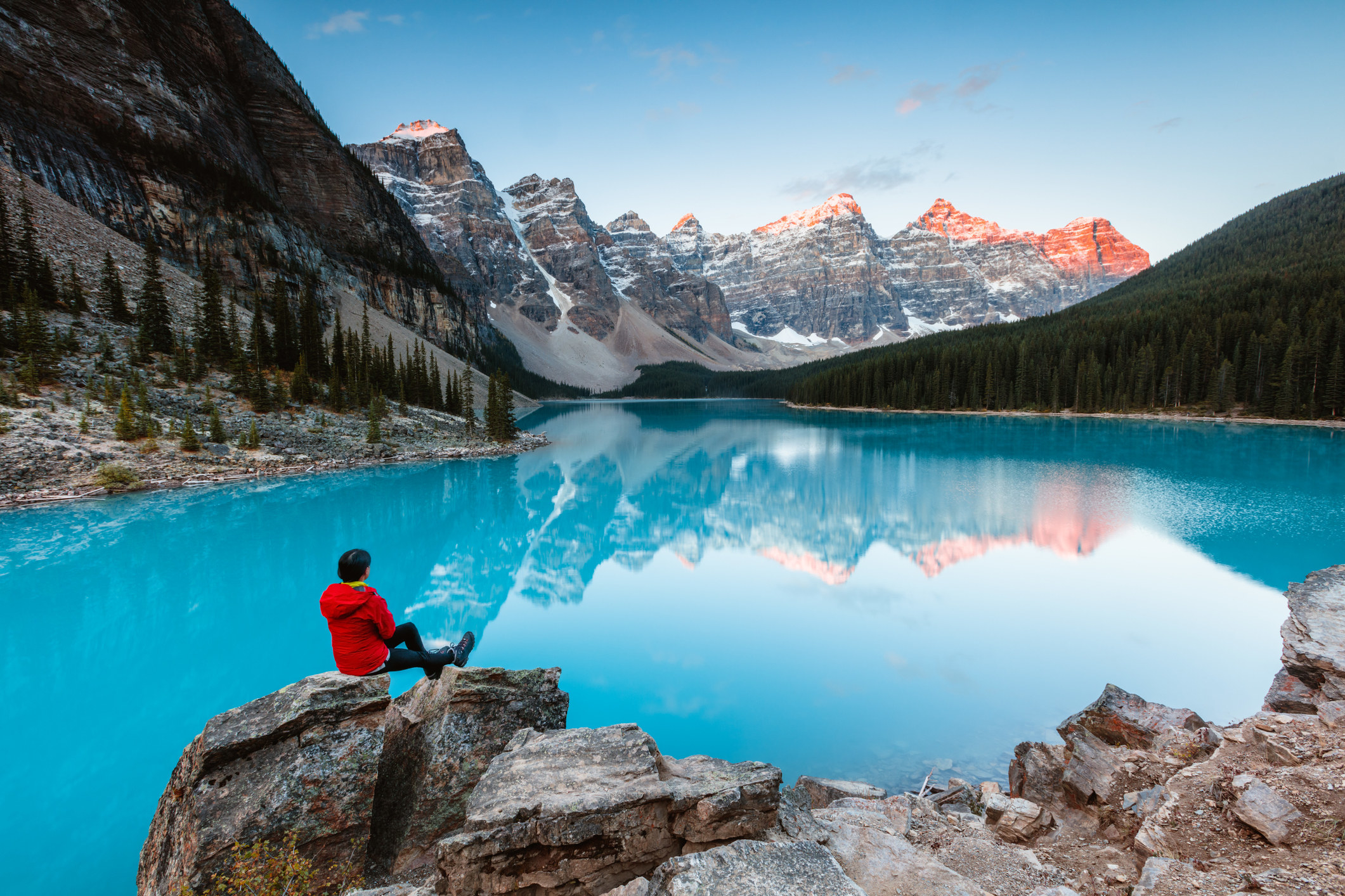 A woman sitting on a rock in front of Moraine Lake