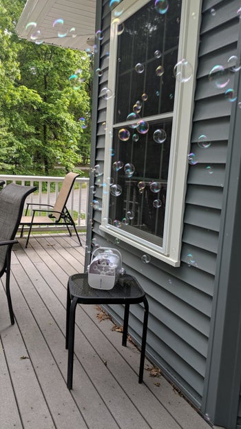 reviewer's photo of the bubble machine pumping out bubbles on their deck