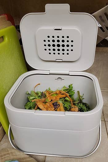 a reviewer photo of the open compost bin filled with food scraps