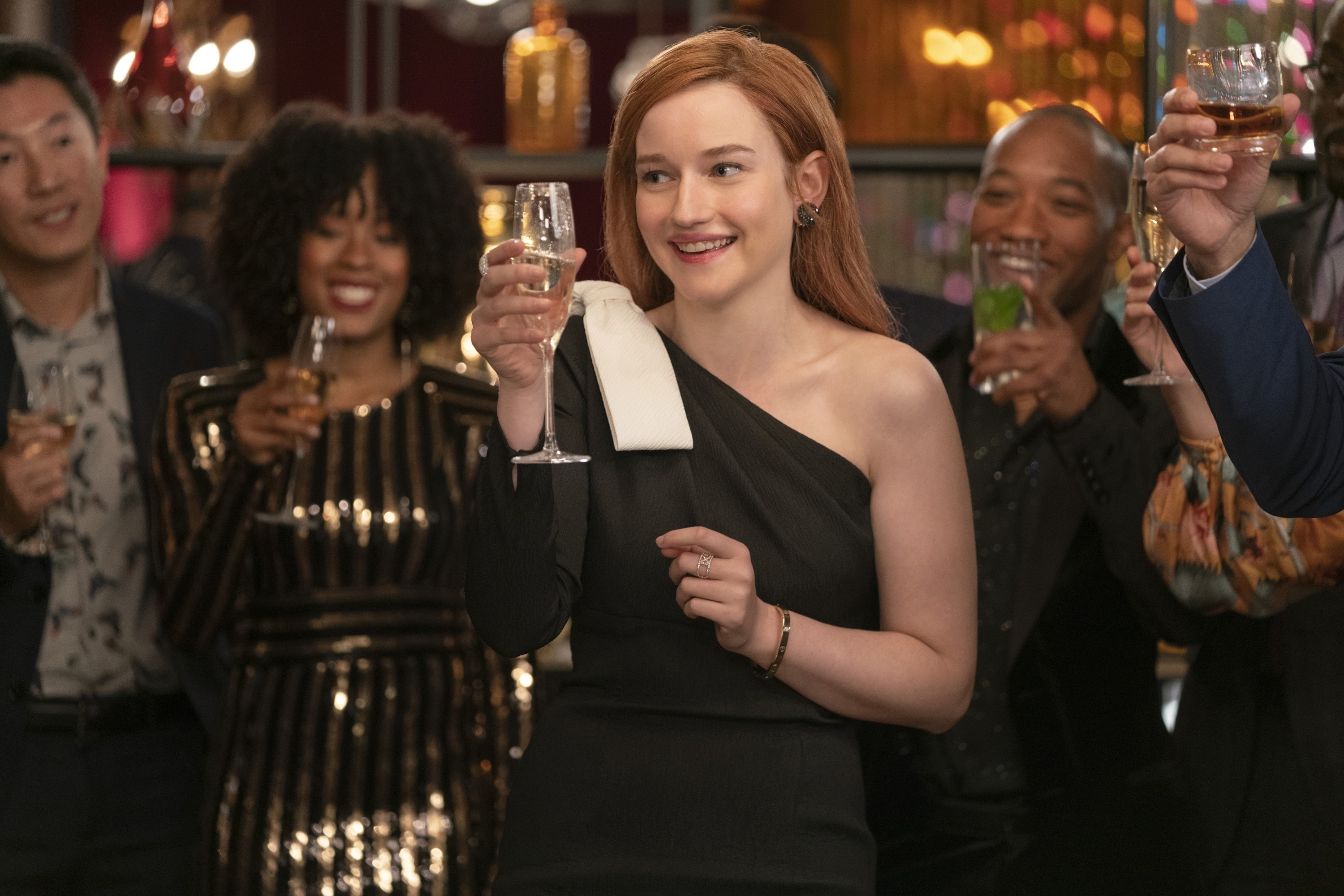 dressed in elegant one-shouldered gown, Anna toasts her champagne with her peers