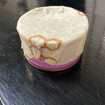 a reviewer photo of a can with bees wax wrapped covering the top