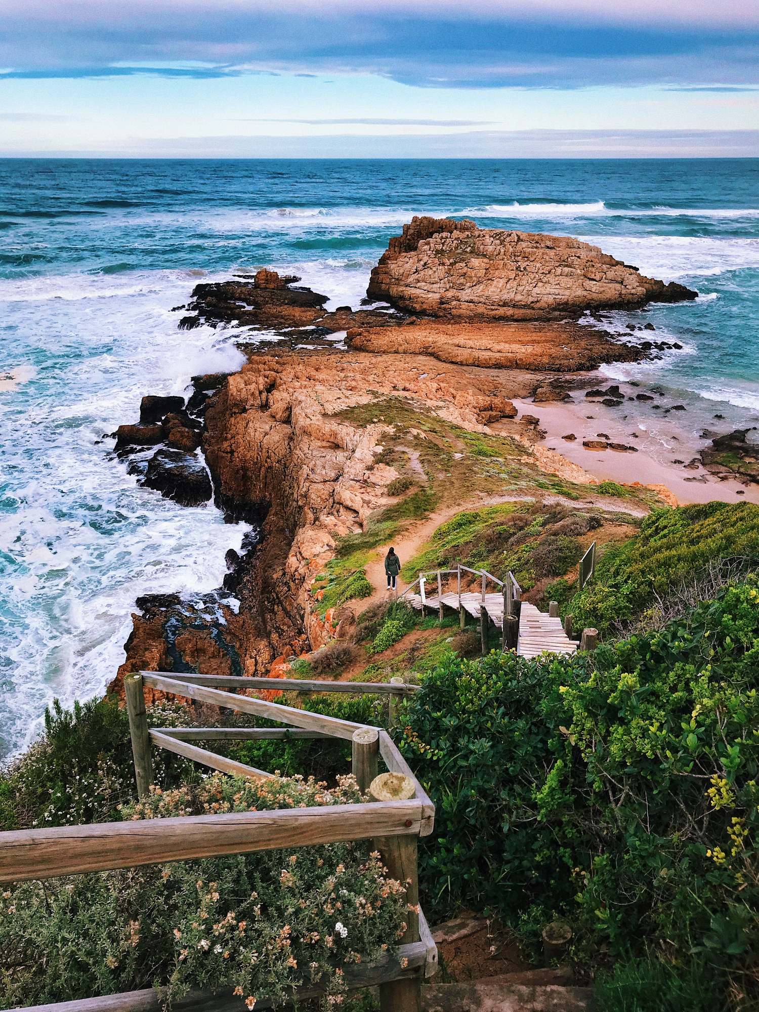 A wooden staircase leading down to a rocky beach in Knysna