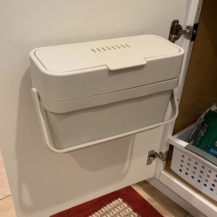 a reviewer photo of the compost bin mounted on the back of a cabinet door