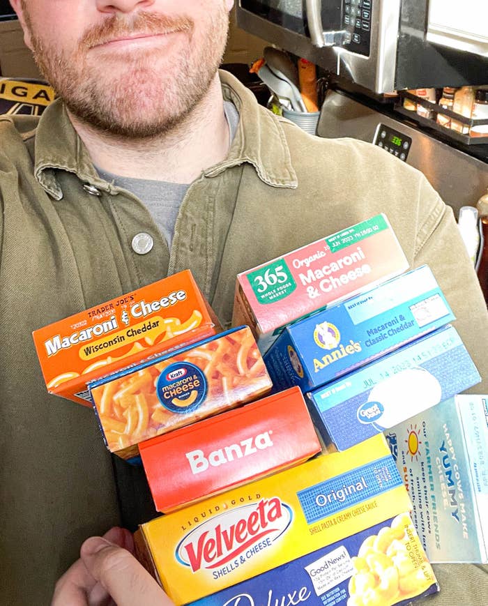 Author holding up a variety of boxes of mac &#x27;n&#x27; cheese while taking a selfie
