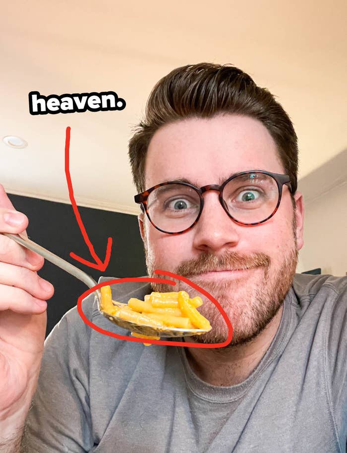 Author holding up a bite of mac &#x27;n&#x27; cheese on a spoon with text: &quot;heaven&quot;