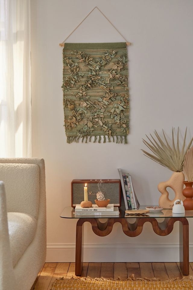 the olive green tapestry which hangs from a wooden dowel