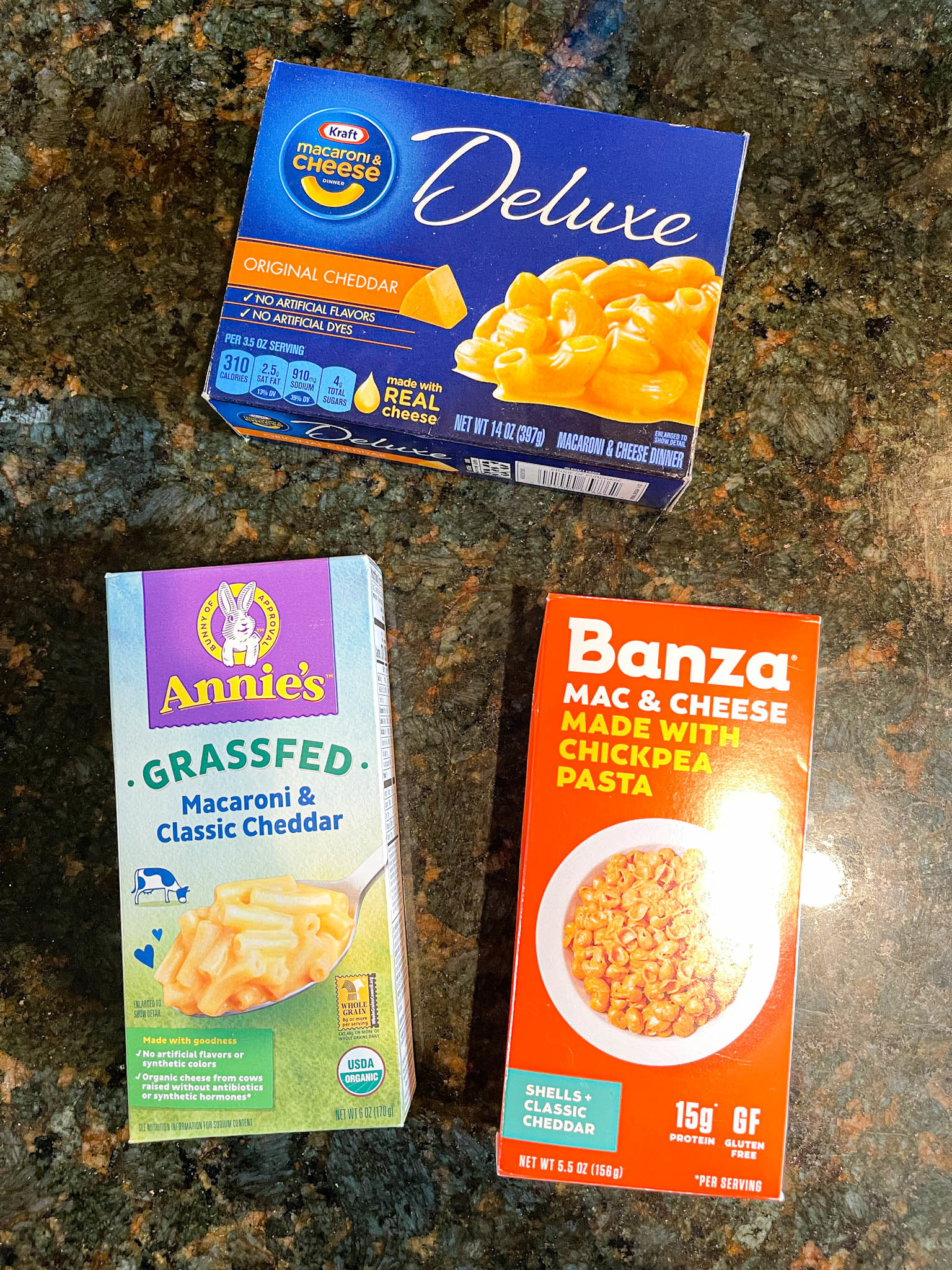 Three mac &#x27;n&#x27; cheese boxes: Kraft Deluxe, Annie&#x27;s Grassfed, and Banza
