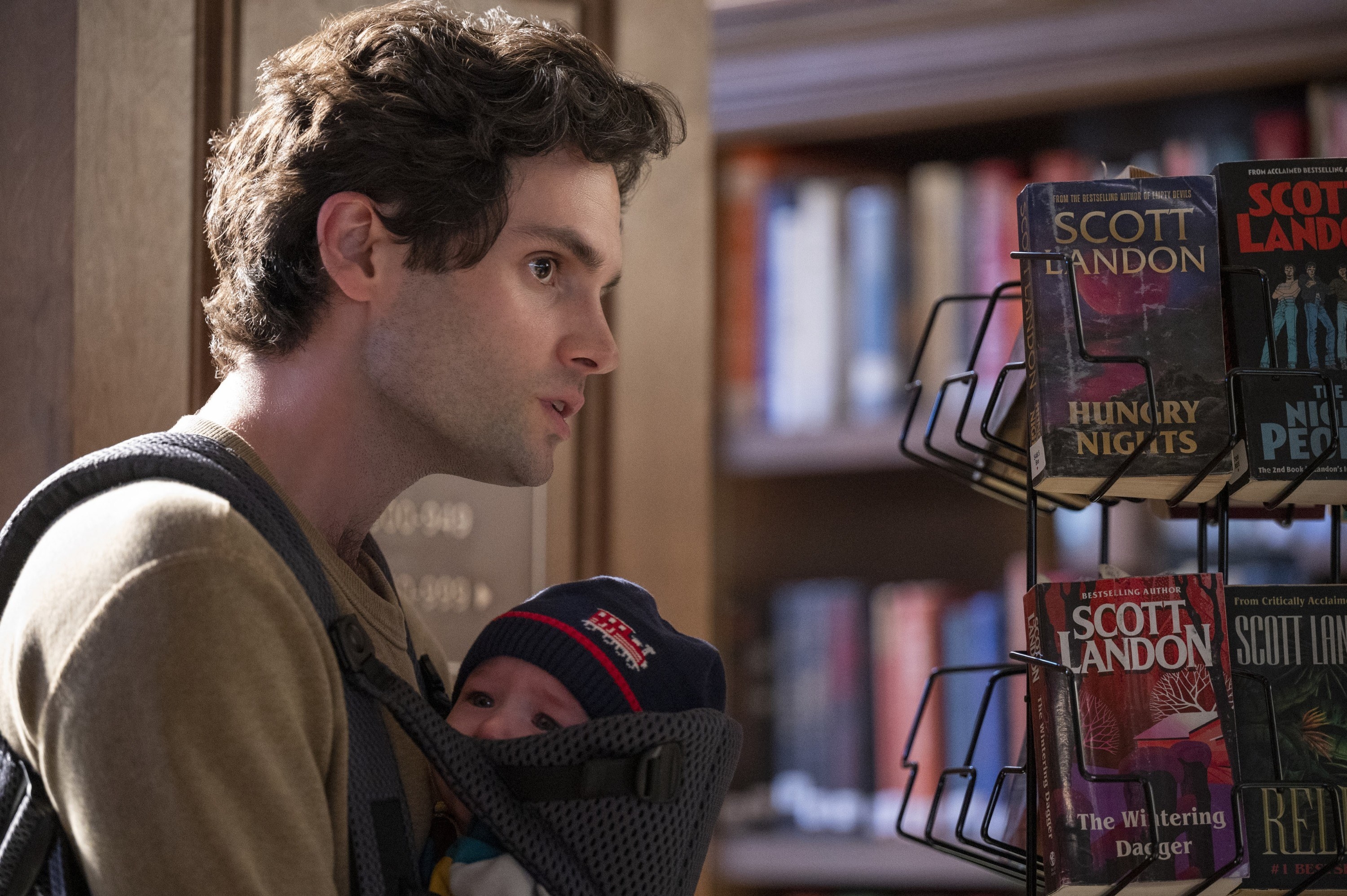 Joe carries his baby son at a library in &quot;You&quot; Season 2