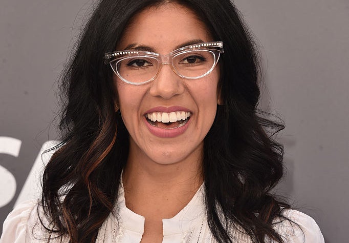 Close up of Stephanie Beatriz in clear cat-eye glasses