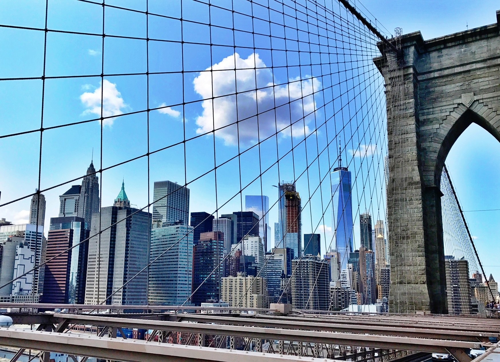 A person walking by the Brooklyn Bridge.