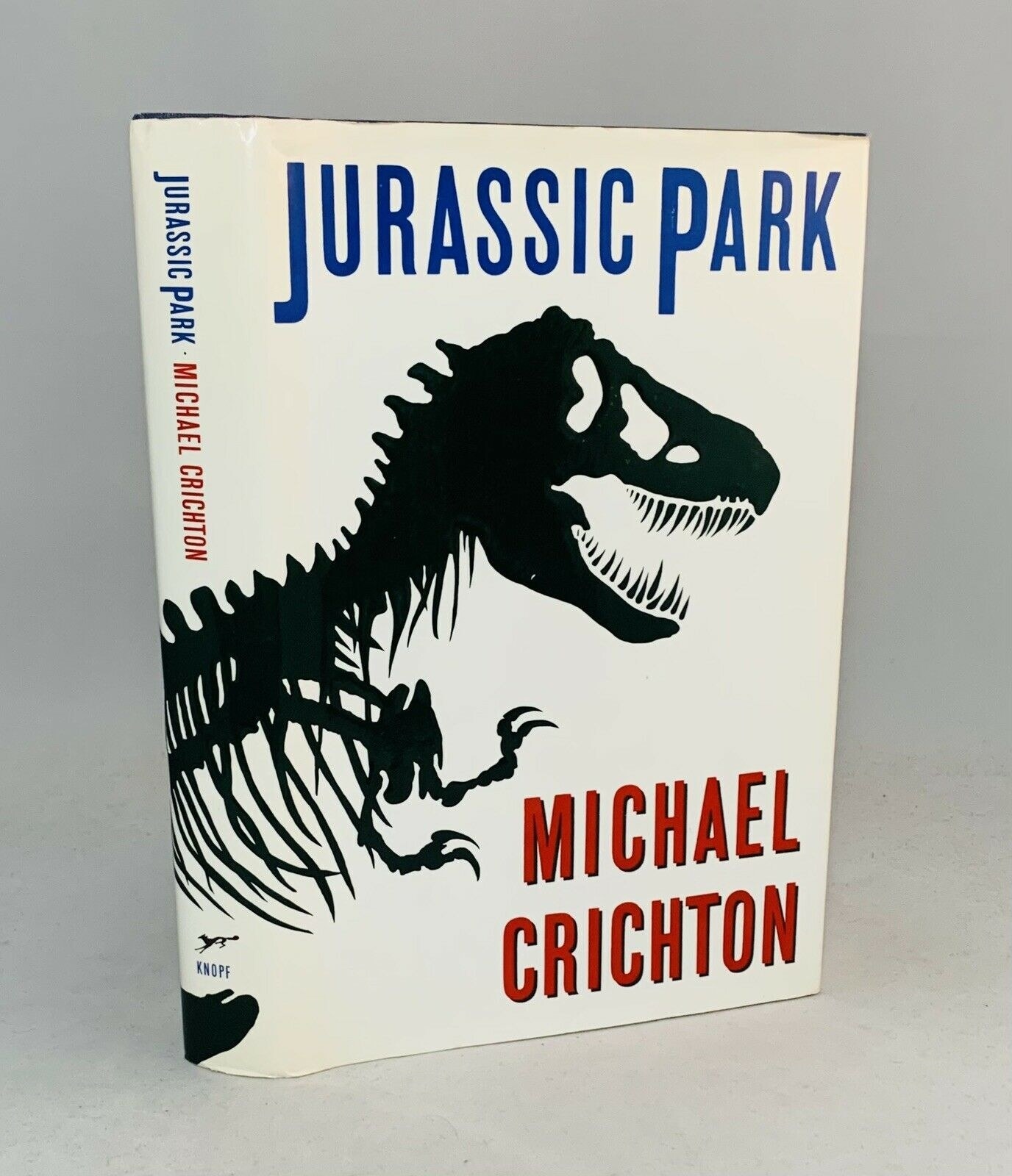 a first edition of Jurassic Park book featuring a skeleton of t-rex on the cover