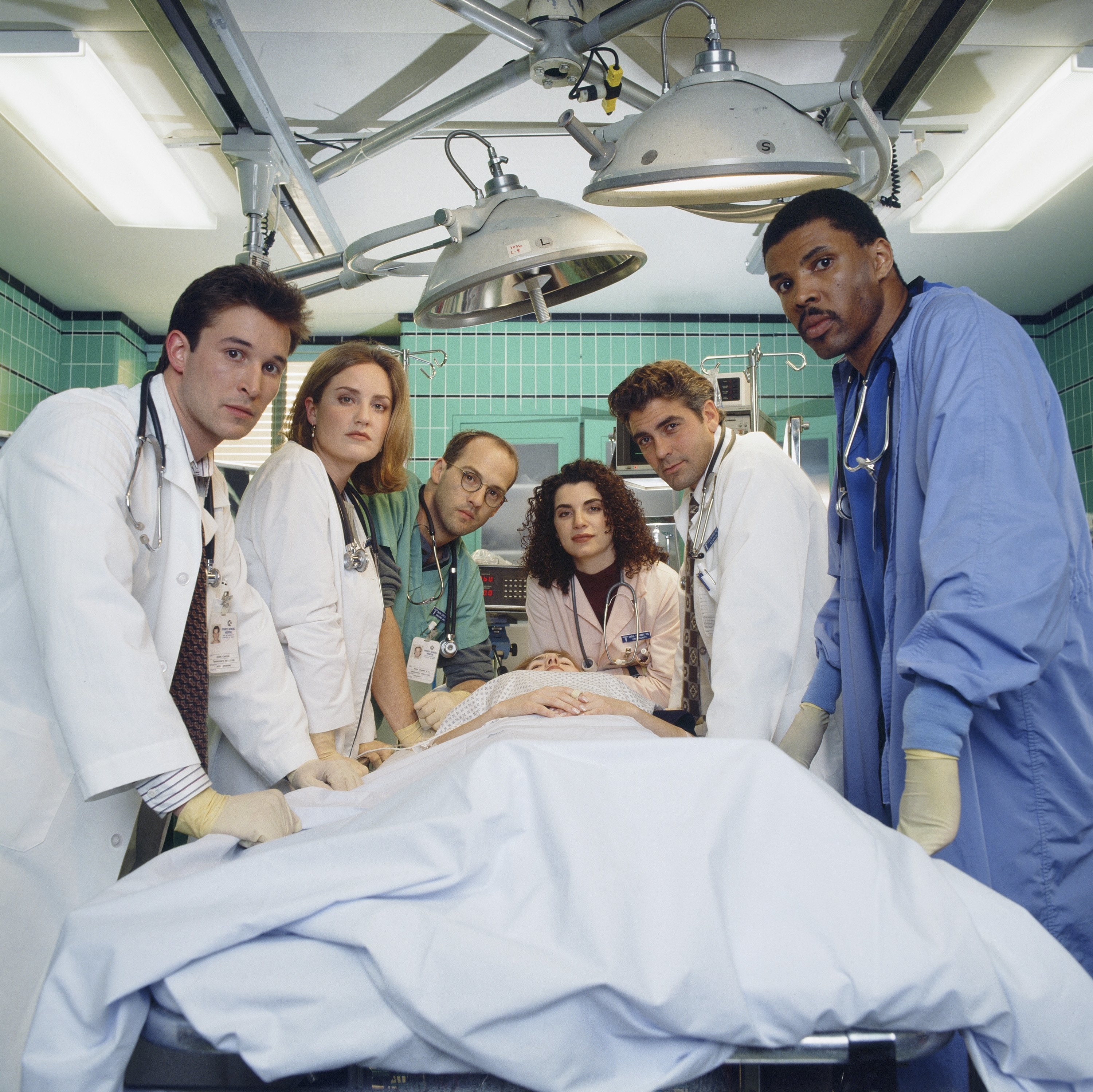 promo photo of the ER cast in an operating table