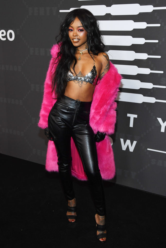Maliibu at the Savage X Fenty show wearing a metallic bralette and leather pants with a fuzzy oversized coat