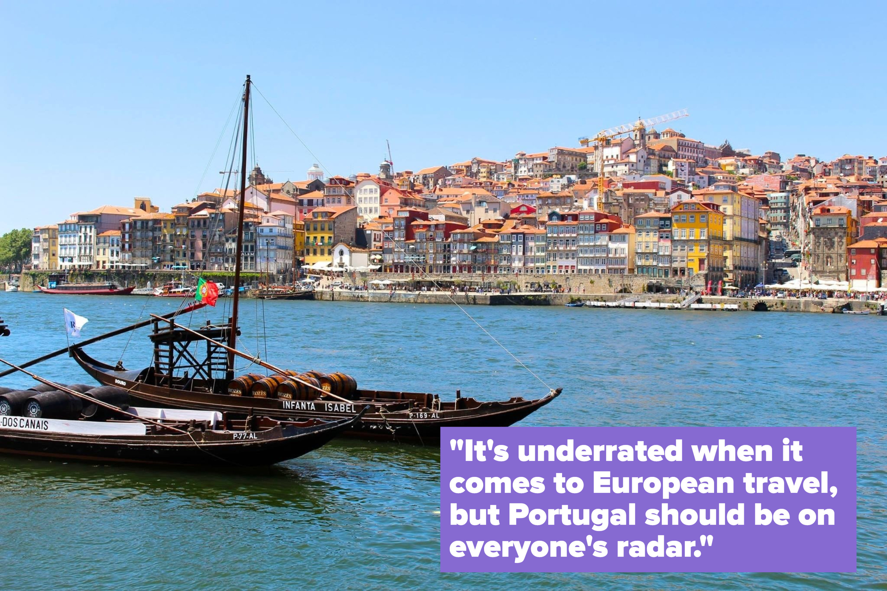 Boats in a river and a colorful city in the backdrop.